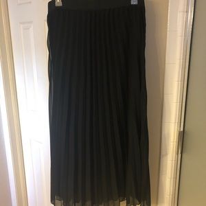 Pleated sheer over black skirt.